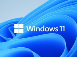 Značkový motív Windows 11: modrý rozvlnený útvar Bloom na svetlom pozadí, v strede štvorcové logo Windows a nápis Windows 11.