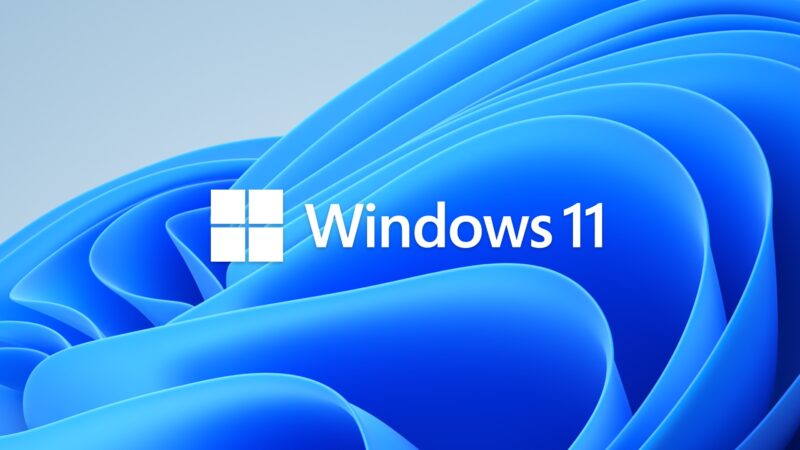 Značkový motív Windows 11: modrý rozvlnený útvar Bloom na svetlom pozadí, v strede štvorcové logo Windows a nápis Windows 11.