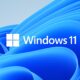 Značkový motív Windows 11: modrý rozvlnený útvar Bloom na svetlom pozadí, v strede štvorcové logo Windows a nápis Windows 11.