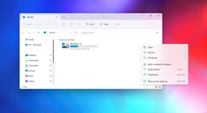 Okno Prieskumníka súborov v systéme Windows 11 s otvoreným priečinkom Tento počítač a diskom Windows (C:); vpravo je rozbalená kontextová ponuka s položkami Zobraziť, Zoradiť podľa, Zoskupiť podľa, Vlastnosti a Zobraziť ďalšie možnosti, v pozadí farebná plocha.