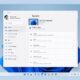 Okno Nastavení Windows 11 otvorené na stránke Systém, s bočnou ponukou položiek ako Bluetooth a zariadenia, Personalizácia či Windows Update a s dlaždicami Obrazovka, Zvuk a Oznámenia; pod oknom je panel úloh so zarovnanými ikonami v strede.