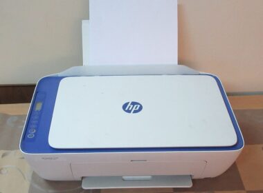 Biela multifunkčná atramentová tlačiareň HP DeskJet s modrým rámom a papierom v zásobníku